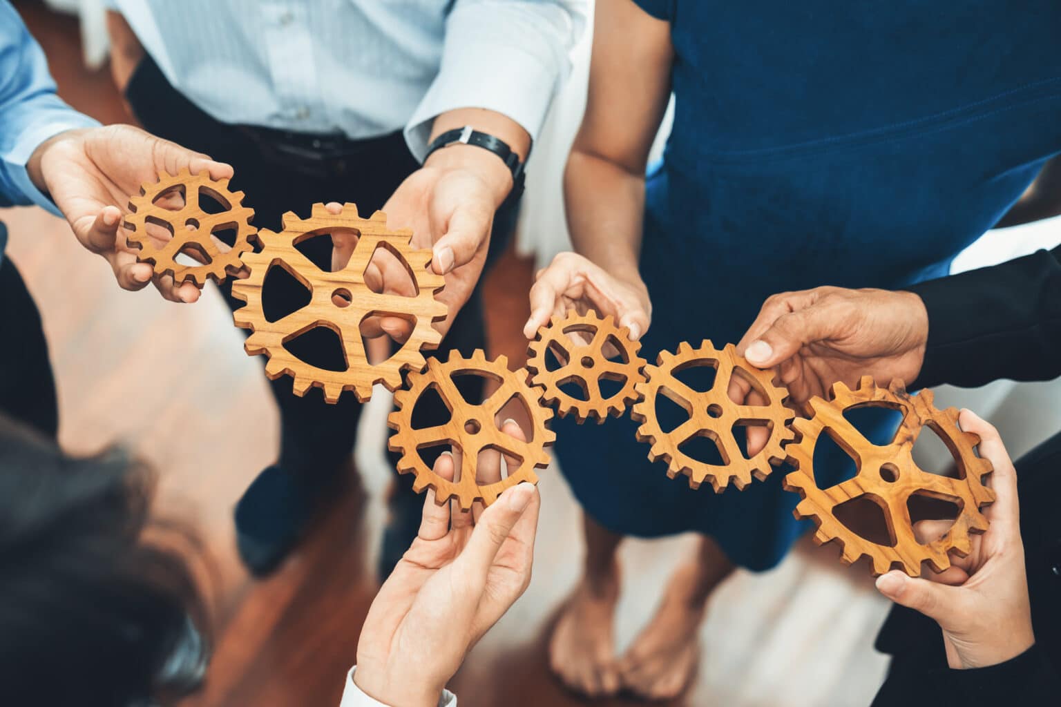 Office worker holding cog wheel as unity and teamwork in corporate workplace concept. Diverse colleague business people showing symbol of visionary system and mechanism for business success. Concord